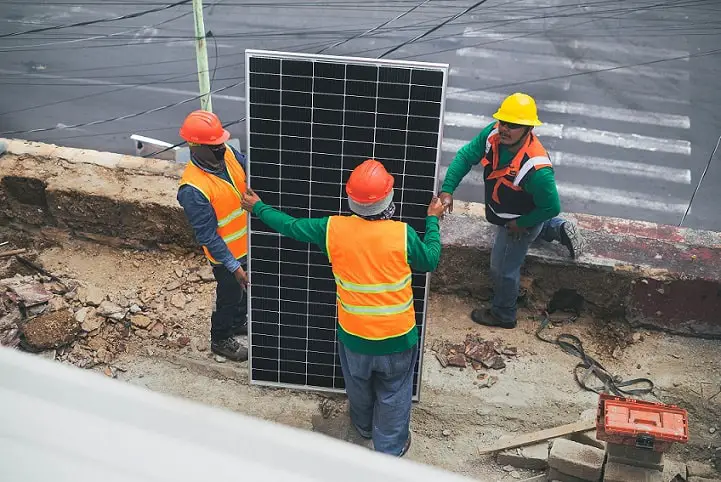 employees moving solar panel